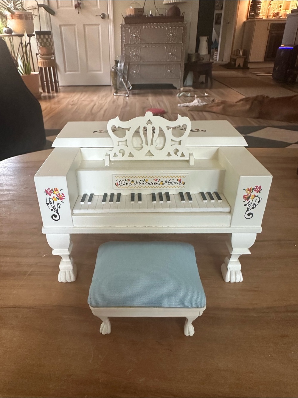 White wooden musical Piano with Hand-Painted Floral Decals and Blue Bench